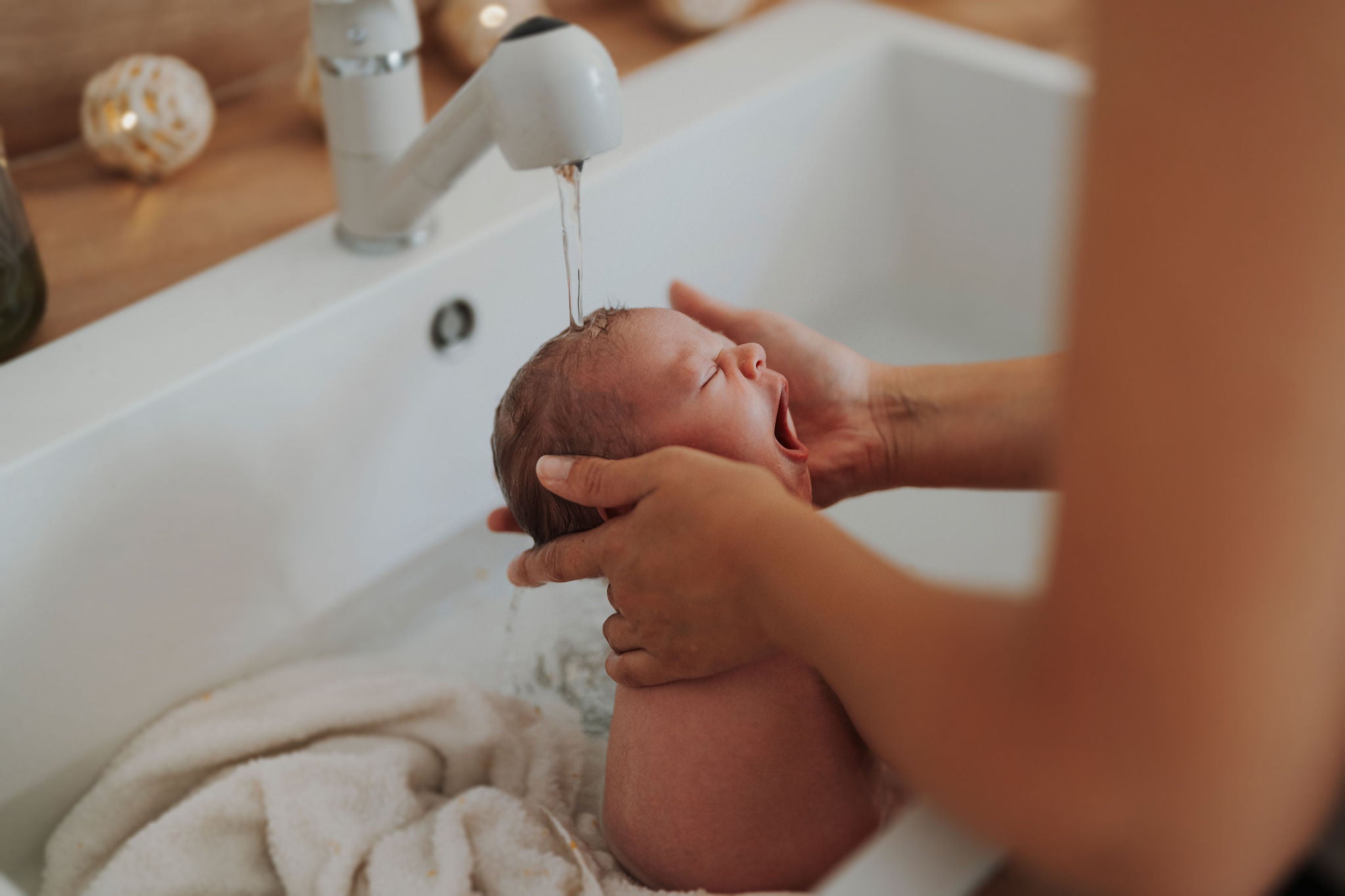 Bain thérapeutique bébé guidé par Charlotte TRAMIER, accompagnante parentale et périnatale. Soin bébé. Un moment de détente et d'émotion pour parents et bébé.